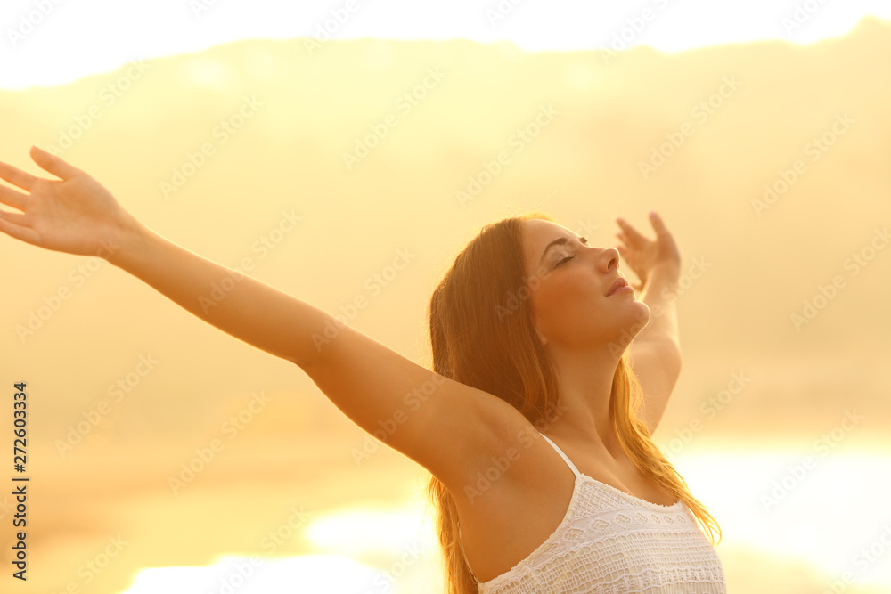 Relaxed woman stretching arms breathing fresh air at sunset - obrazy, fototapety, plakaty 