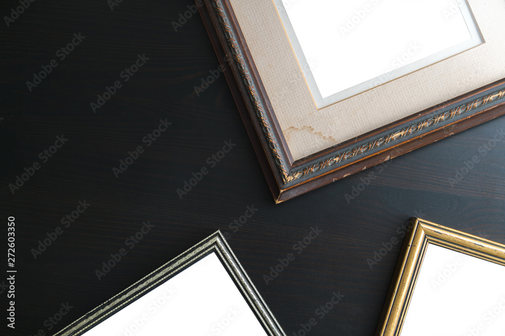 Fototapeta premium Blank empty frames on dark wooden background. Art gallery, museu