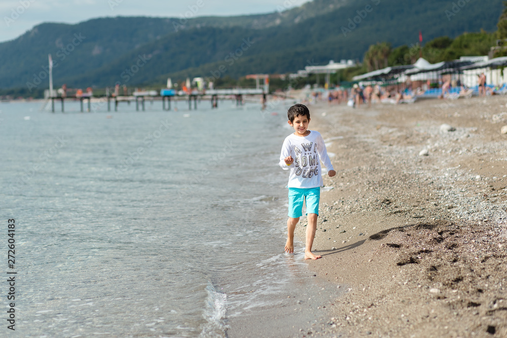 Boy is walking by the beach