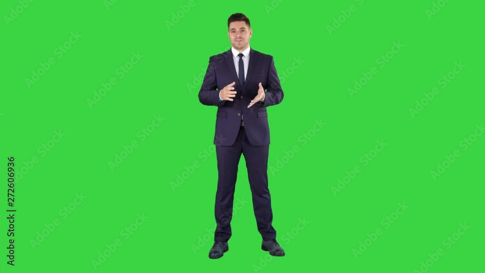 Handsome businessman looking in camera and talking on a Green Screen, Chroma Key.