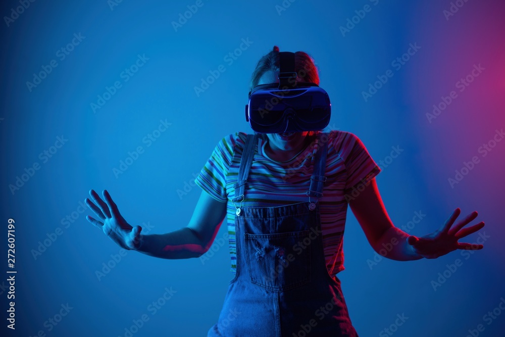 Young cute girl playing vr. with creative blue-red light. it is emeanantly and fun Young cute girl playing vr. with creative blue-red light. it is emeanantly and fun