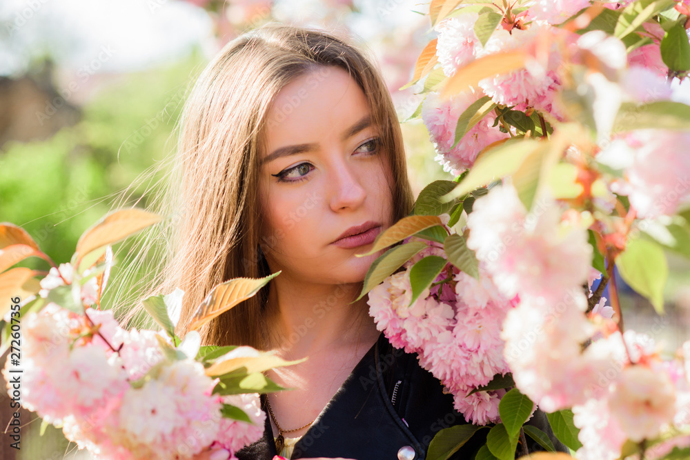 Naklejka premium Spring in my head. blossom smell, allergy. girl in cherry flower. Sakura tree blooming. natural summer beauty. skincare and spa. Natural cosmetics for skin. woman in spring flower bloom