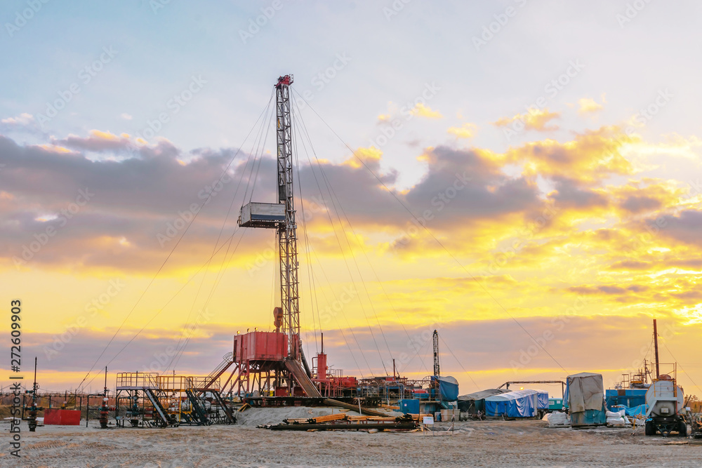 Drilling a deep well mobile drilling rig in an oil and gas field. The field is located in the Far North in the taiga. Beautiful dramatic sunset sky in the background. Drilling a deep well mobile drilling rig in an oil and gas field. The field is located in the Far North in the taiga. Beautiful dramatic sunset sky in the background.