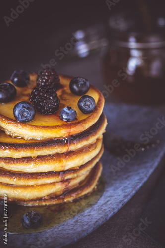 American Pancakes with Organic Berries and Maple Syrup on Dark Background. Classic Homemade Breakfast.