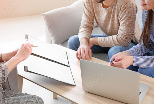 Real estate agent working with young couple in office