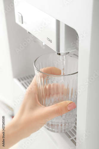Woman pouring water from cooler into glass
