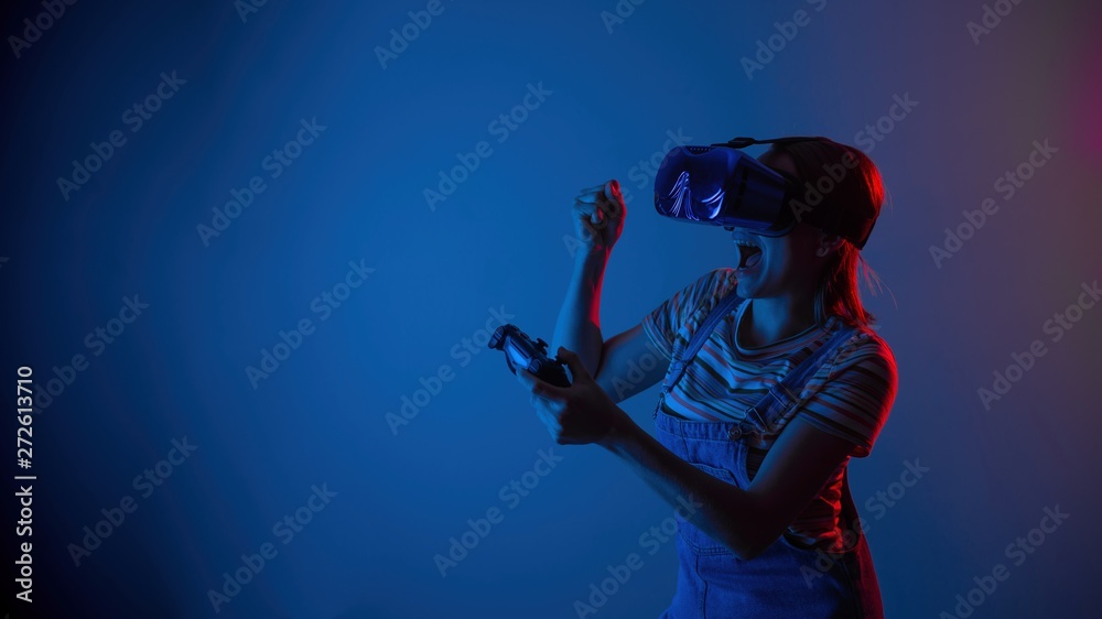 The game vr. The girl in the helmet and the controller plays a game with creative light. concept of cyber sports. games. viral reality