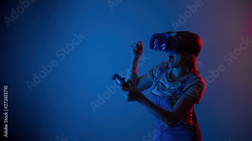 The game vr. The girl in the helmet and the controller plays a game with creative light. concept of cyber sports. games. viral reality