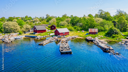 Fotografija Stone filled jetties and fishing sheds seen from the sea
