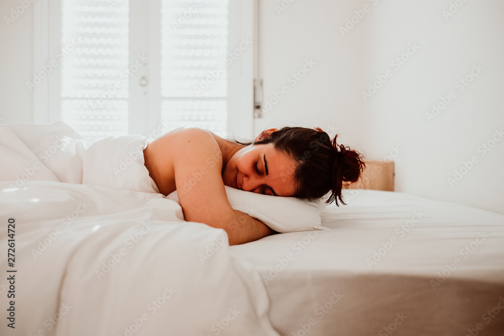 .Young and pretty woman newly woken up, playing in bed with the beautiful light of dawn. Sexy and attractive woman. Lifestyle. .Young and pretty woman newly woken up, playing in bed with the beautiful light of dawn. Sexy and attractive woman. Lifestyle.