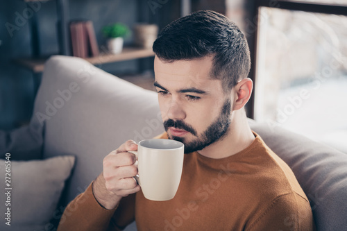 Close-up portrait of his he nice-looking attractive bearded peaceful guy spending weekend sitting on divan drinking latte espresso lover at industrial loft brick interior style living-room indoors