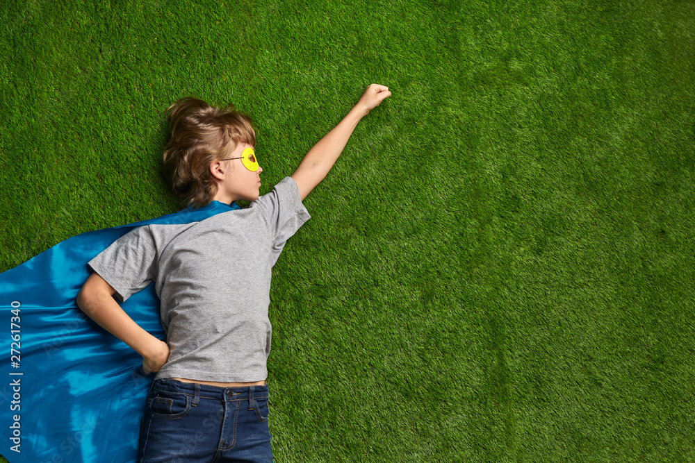 Little superhero flying against lawn Little superhero flying against lawn