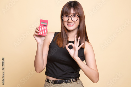 Asian woman show OK with calculator.