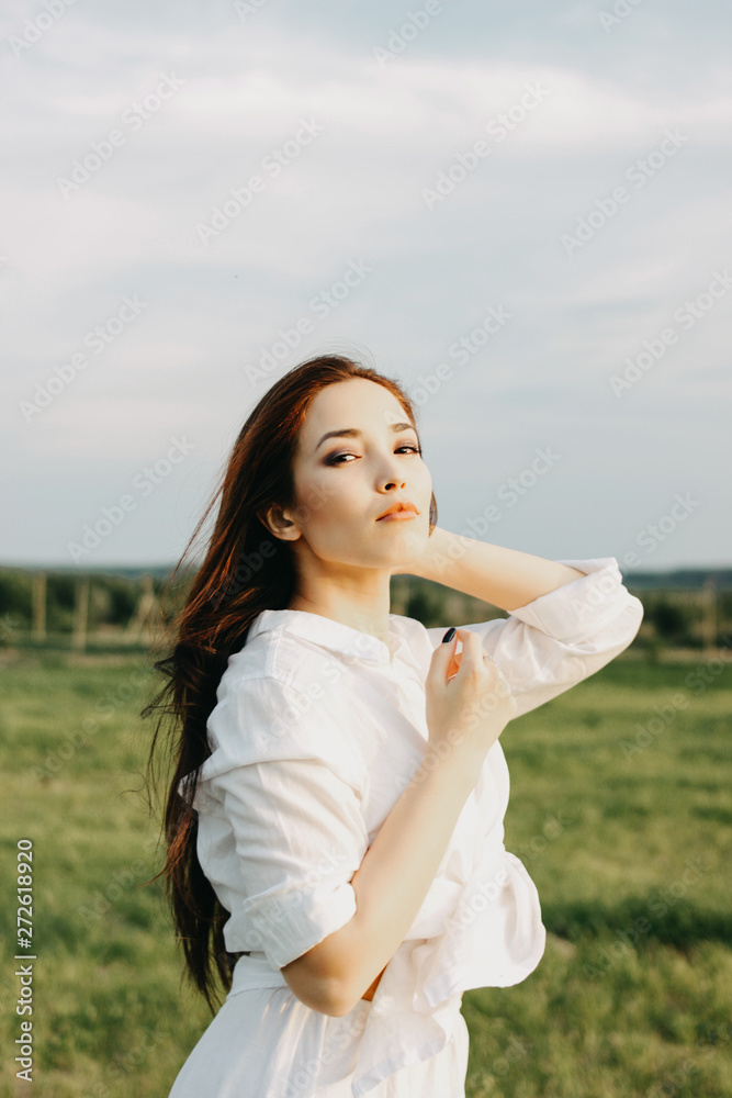 Portrait of beautiful carefree long hair asian girl in white clothes on field at sunset. Sensitivity to nature concept Portrait of beautiful carefree long hair asian girl in white clothes on field at sunset. Sensitivity to nature concept
