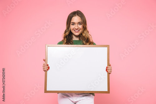 Smiling blonde woman holding blank board and looking at camera