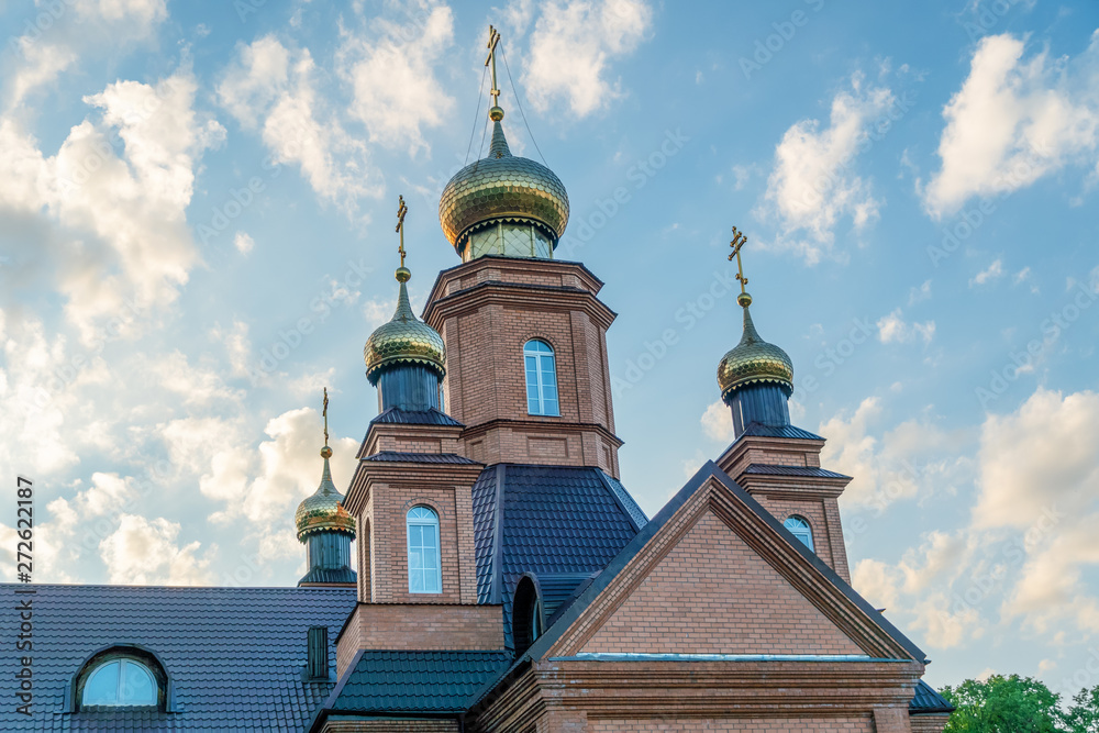 Part of the Orthodox Church with four domes and crosses close-up against the blue sky. Orthodox cross