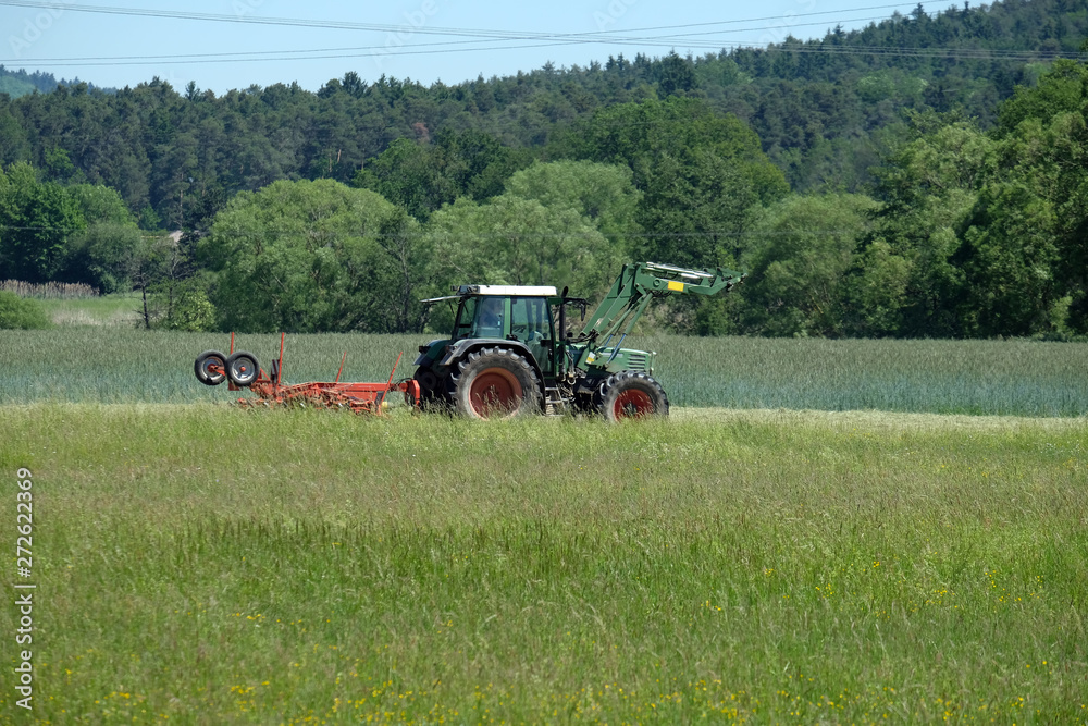 Obraz premium Landwirt beim Rechen im Altmühltal