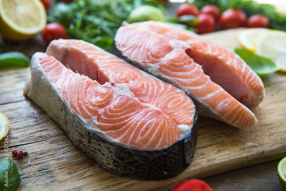 Salmon. Raw Trout Red Fish Steak served with Herbs and Lemon. Cooking Salmon, sea food. Healthy eating concept Salmon. Raw Trout Red Fish Steak served with Herbs and Lemon. Cooking Salmon, sea food. Healthy eating concept