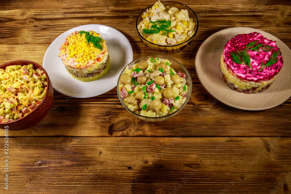Set of festive mayonnaise salads on wooden table Set of festive mayonnaise salads on wooden table