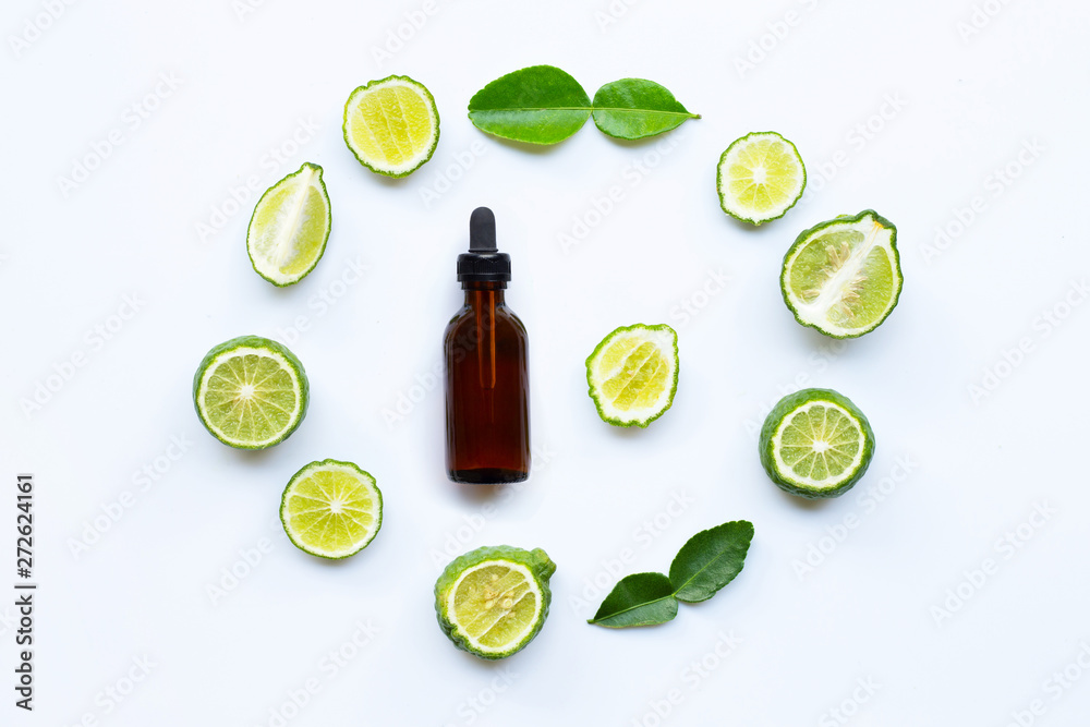 Bottle of essential oil and fresh kaffir lime or bergamot fruit with leaves