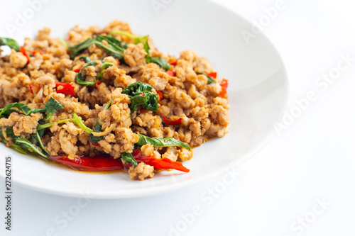 Stir-fried hot and spicy pork with basil on white.