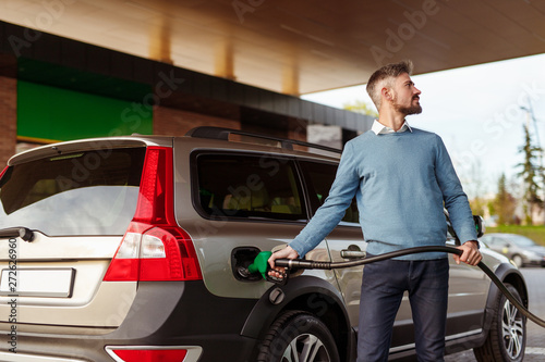 Obraz na plátně Man refueling vehicle and looking away