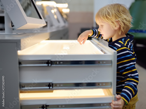 Canvastavla Little сaucasian boy is looking an exposition in a scientific museum