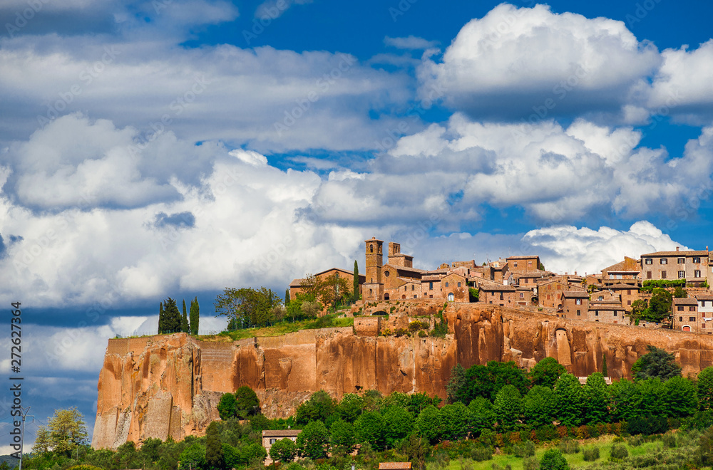 View of Orvieto medieval historic center with its characteristic ancient buildings made of tuff stone and beautiful clouds above