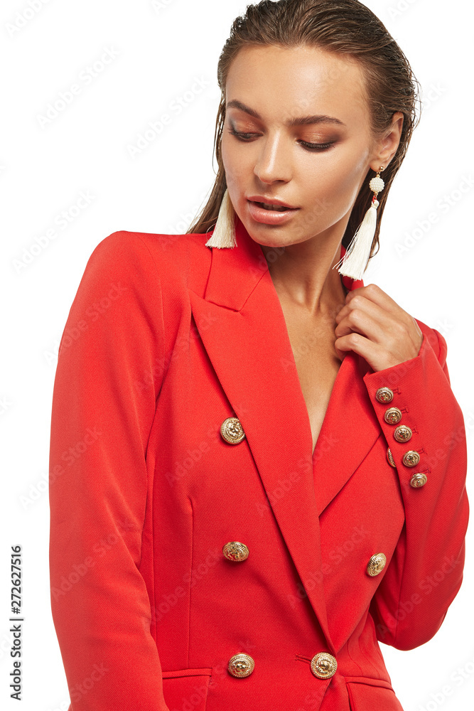 Shot of girl with tied back hair, wearing red blazer and long earrings, decorated with creamy balls made of beads and tassels. The lady is tilting head against the snowy background, looking down. Shot of girl with tied back hair, wearing red blazer and long earrings, decorated with creamy balls made of beads and tassels. The lady is tilting head against the snowy background, looking down.