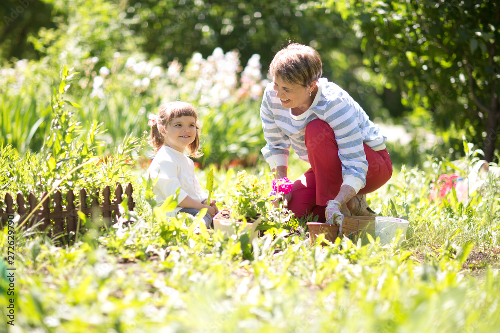 Grandmother with her granddaughter working in the garden. Grandmother with her granddaughter working in the garden.