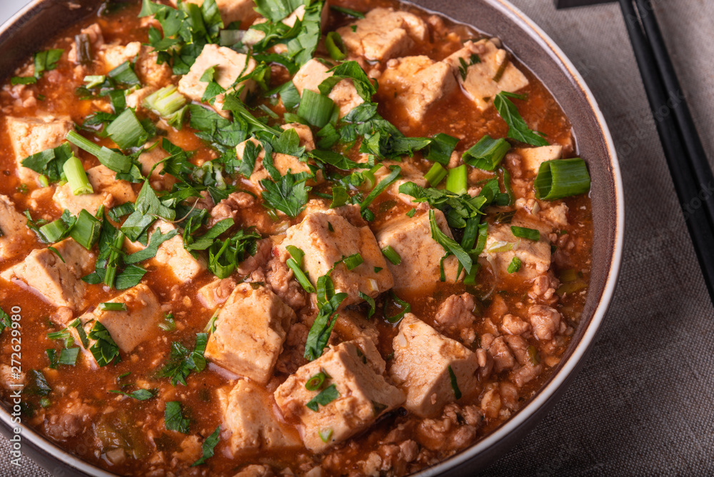 Traditional Chinese dish tofu with minced meat and tofu cheese in a bowl on a linen rustic napkin, close-up Traditional Chinese dish tofu with minced meat and tofu cheese in a bowl on a linen rustic napkin, close-up