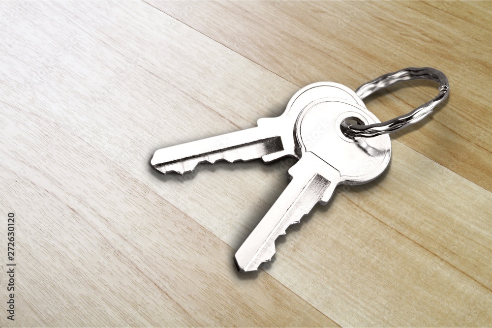 House keys with house figure on wooden desk House keys with house figure on wooden desk