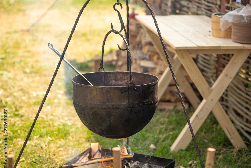Street food - a cauldron with cooked soup over a fire. Street food - a cauldron with cooked soup over a fire.