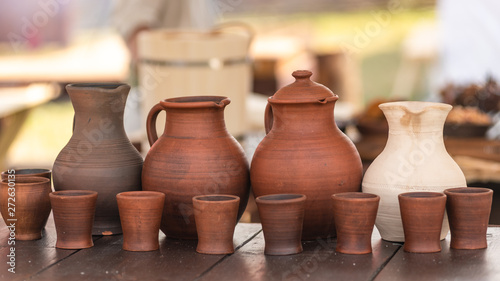 Rustic earthenware jug and mugs on wooden table
