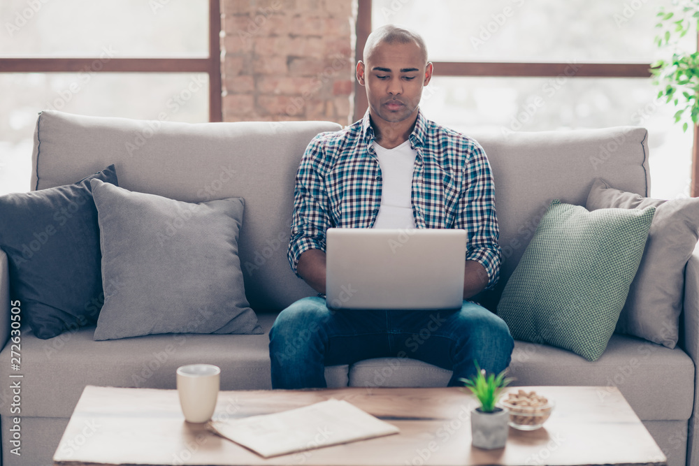 Portrait of charming classy freelancer sit divan trendy stylish cozy dressed checkered fashionable clothing shirt denim jeans concentrated hold hand modern technology room 