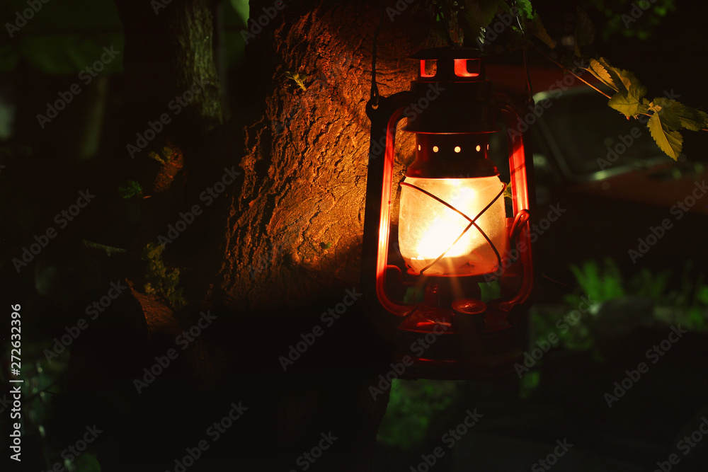 Kerosene lamp in the dark. Kerosene lamp on a tree in the garden