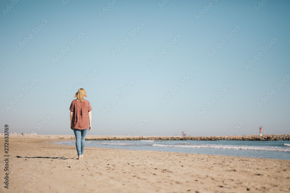 Waling woman on the beach Valencia Spain