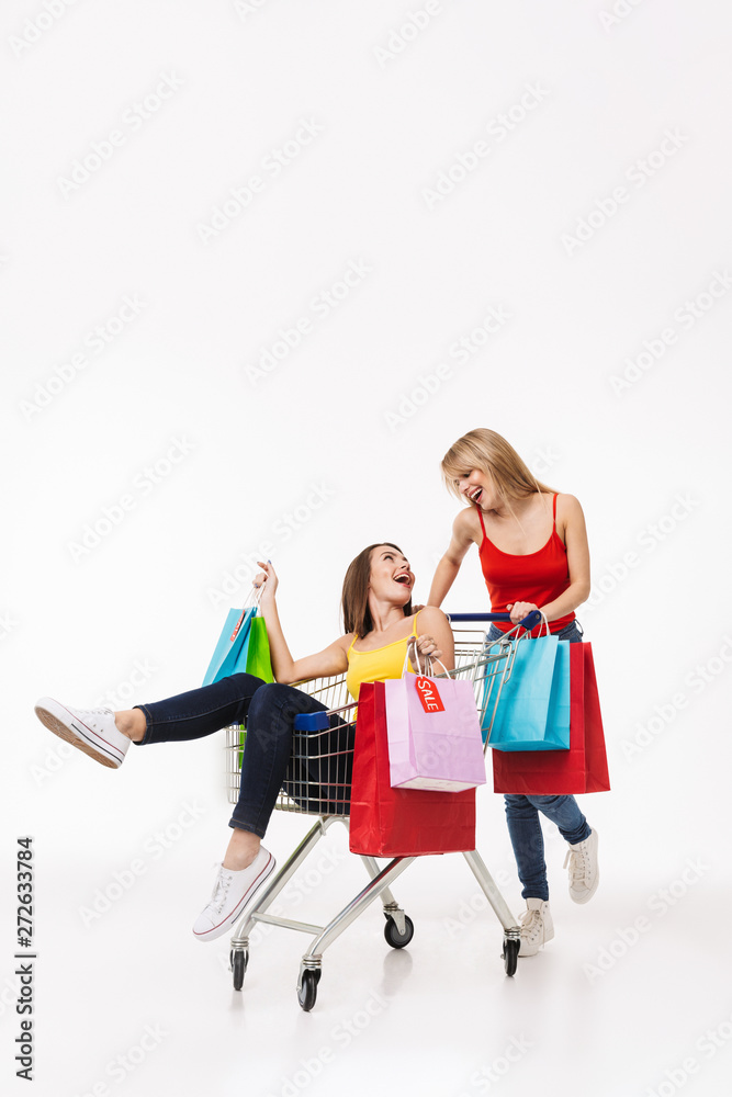Full length of two cheerful young girl shopping together Full length of two cheerful young girl shopping together