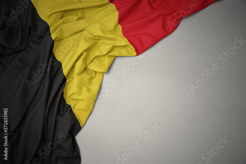 waving national flag of belgium on a gray background.