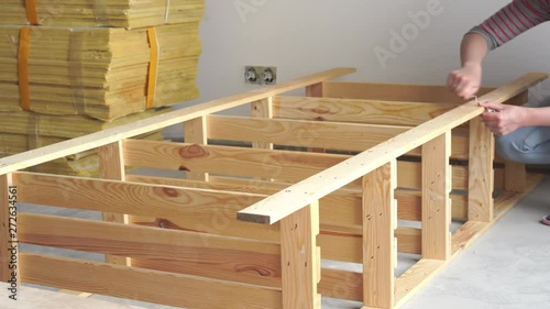 non-female work. young woman assembles wooden furniture indoors. accelerated video