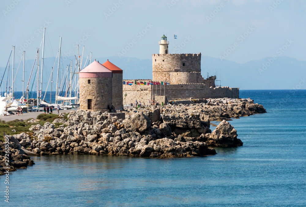 old stone mill on the coast of the Mediterranean sea, Rhodes, Greece, summer