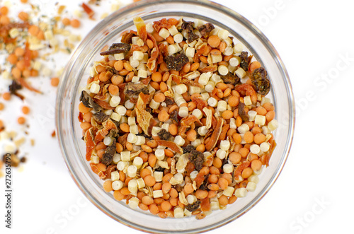 A glass bowl with slices of dry vegetables / spices. Ingredients for cooking. White background.