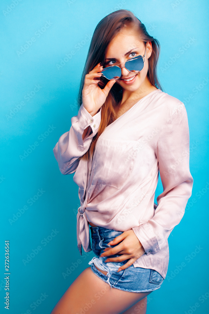 young pretty girl in sunglasses posing happy smiling on blue background, lifestyle people on summer vacation concept young pretty girl in sunglasses posing happy smiling on blue background, lifestyle people on summer vacation concept