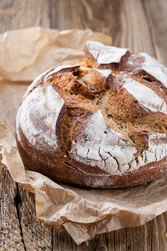 Gold rustic crusty loaves of bread and buns on wooden background. Still life captured from above top view, flat lay.