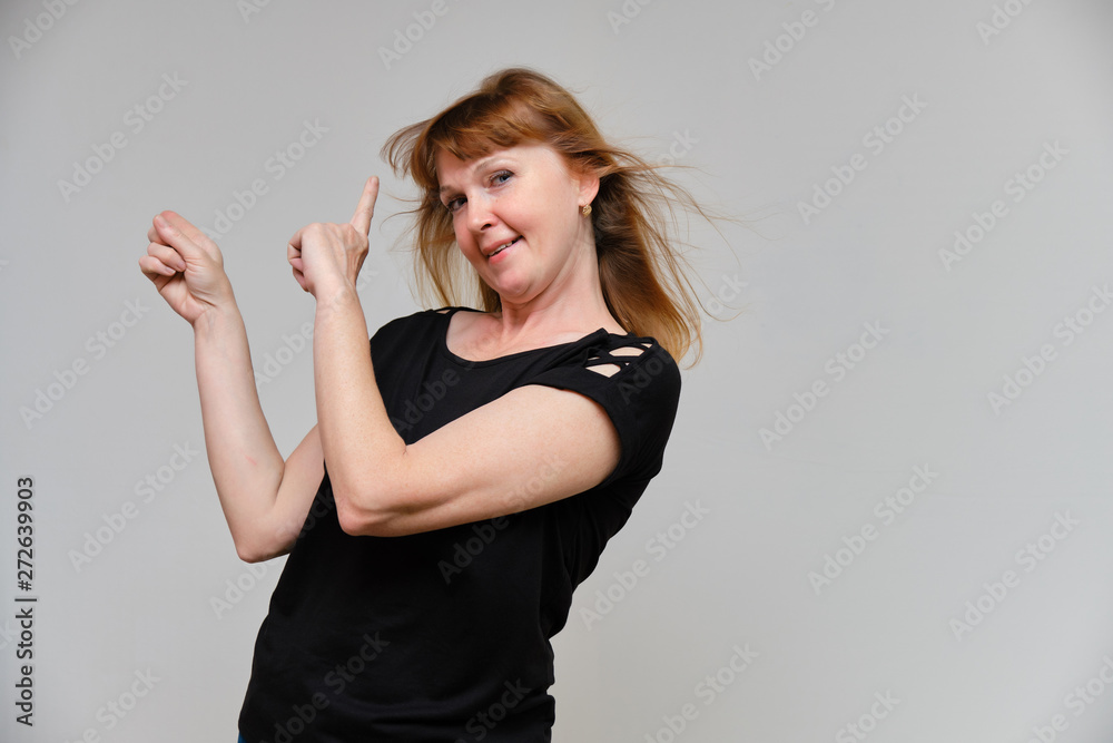 Studio portrait of a beautiful pretty woman aged 40 years on a white background, smiling, showing different emotions, happy with life. In a black sweater with red hair. Directly opposite the camera. Studio portrait of a beautiful pretty woman aged 40 years on a white background, smiling, showing different emotions, happy with life. In a black sweater with red hair. Directly opposite the camera.