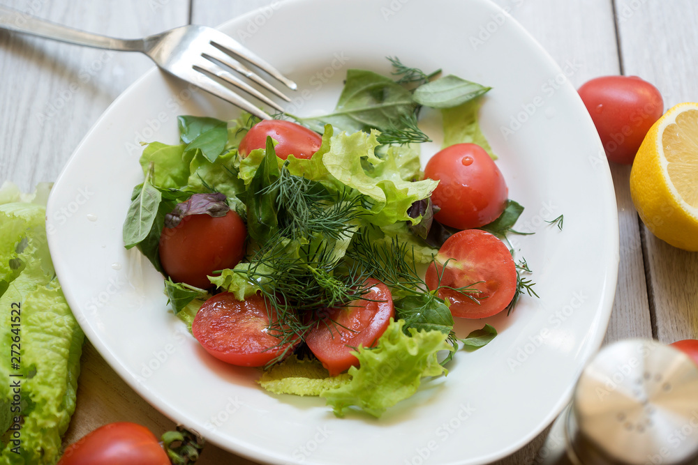 Vegetable salad with fresh lettuce, tomatoes and cucumber in clay pot. Top view.