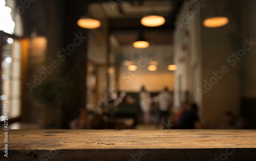 Tableau sur toile image of wooden table in front of abstract blurred background of resturant light