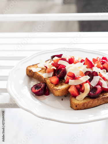 French toast with berries and mascarpone cheese on a light background.