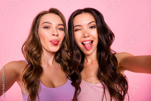 Close up photo of carefree funny funky cute charming ladies make faces photos have free time weekends fellows fellowship stylish trendy youth outfit long haircut isolated pink background
