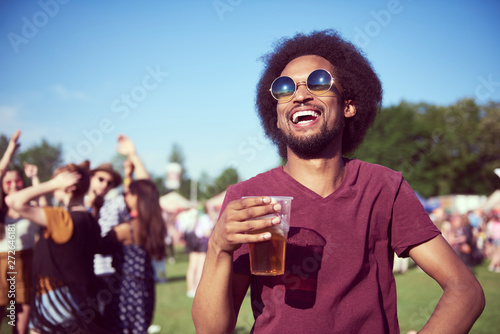 Sticker Happy African man drinking beer in festival